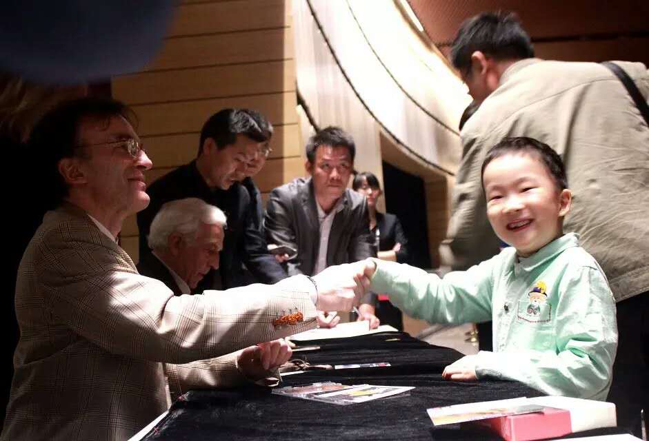 Vovka Ashkenazy greeting a smiling child with a handshake