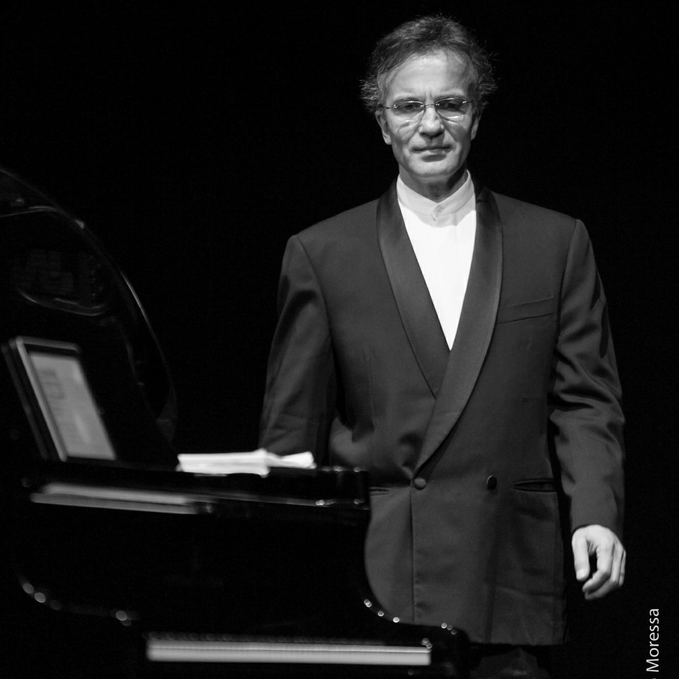 Black-and-white portrait of Vovka Ashkenazy beside a piano; photograph by Moressa
