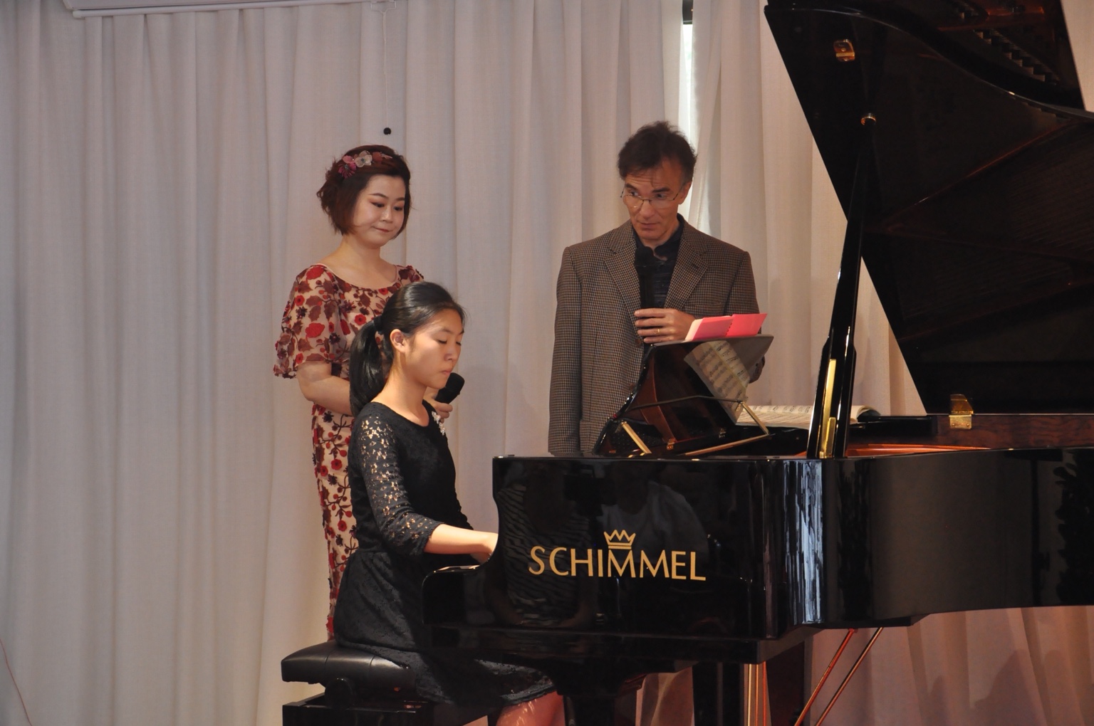 Vovka Ashkenazy discussing music beside a pianist in black at a grand piano